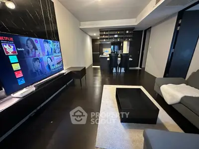 Modern living room with sleek dark flooring and open kitchen layout