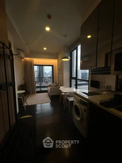 Modern apartment interior with city view, featuring a cozy living area and in-unit washing machine.