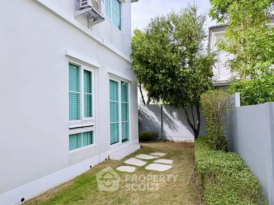 Charming residential exterior with lush garden and modern architecture.