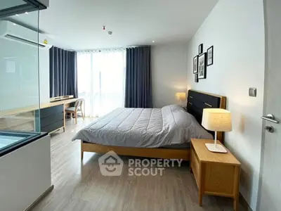 Modern bedroom with stylish decor and natural light, featuring a cozy bed and elegant furnishings.