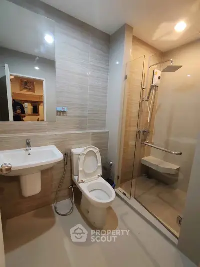 Modern bathroom with glass shower and sleek fixtures in a contemporary apartment.
