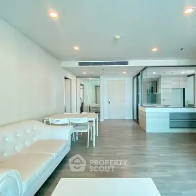 Spacious modern living room with open kitchen and elegant furnishings.