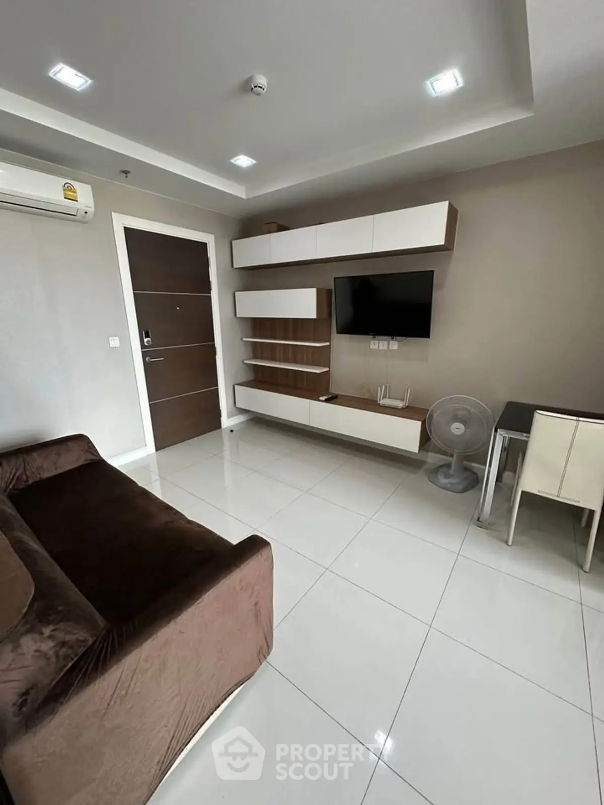 Modern living room with sleek furniture and wall-mounted TV in a stylish apartment.