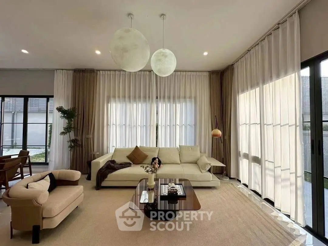 Elegant living room with modern furniture and large windows, perfect for relaxation.