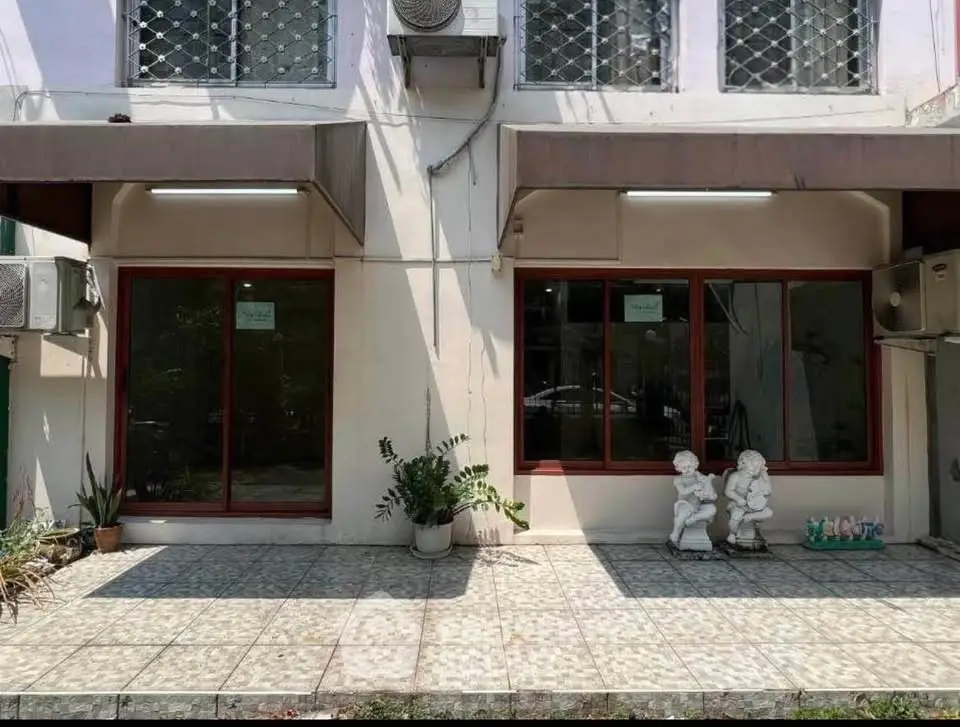 Charming building exterior with decorative statues and potted plants, ideal for commercial or residential use.