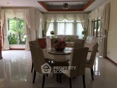 Elegant living room with large windows and stylish dining area