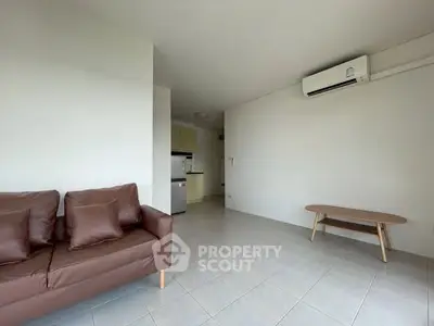 Spacious living room with modern sofa and air conditioning, perfect for relaxation.