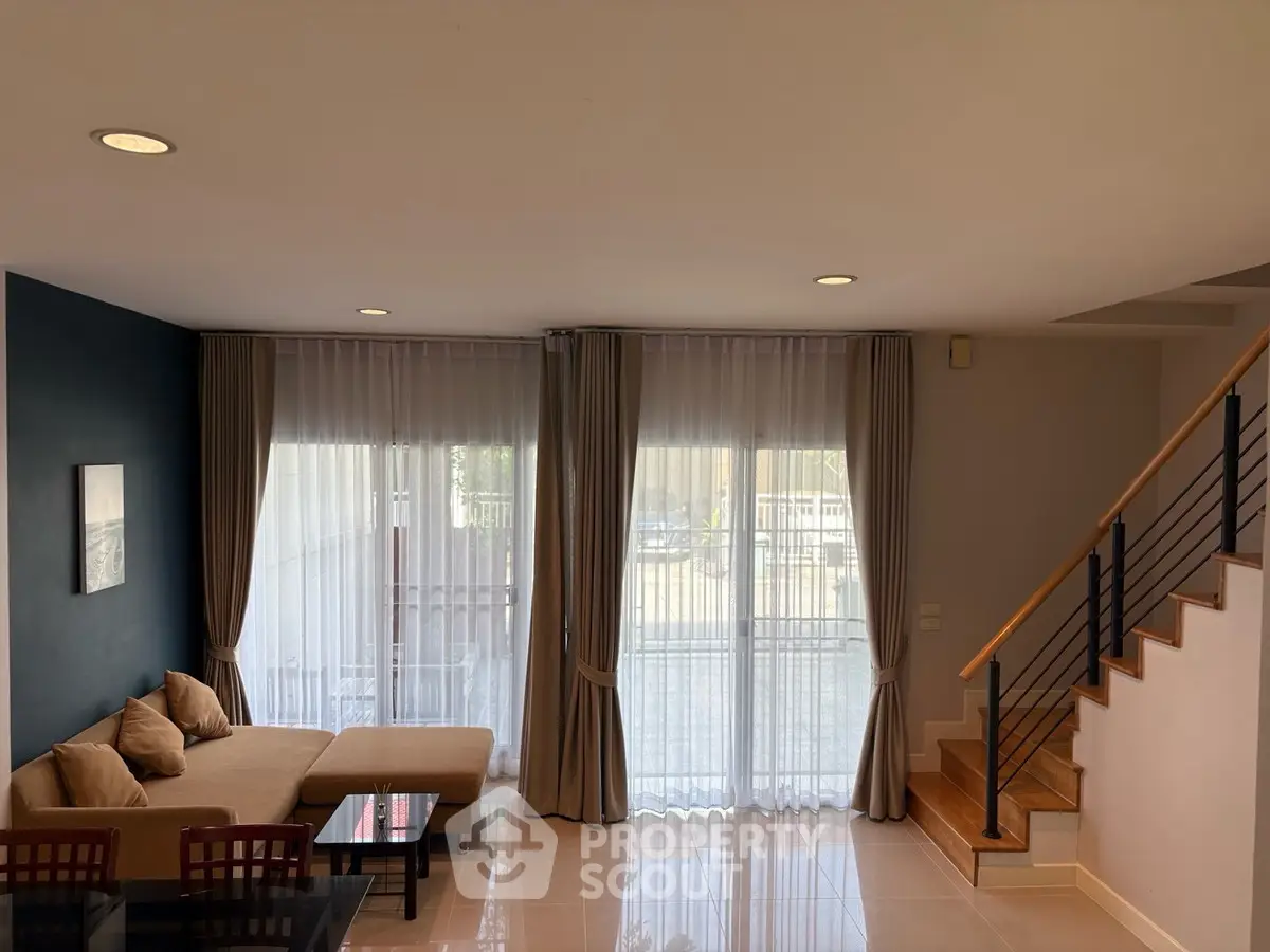 Spacious living room with modern decor and large windows for natural light.