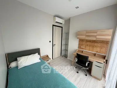 Modern bedroom with study area, featuring sleek furniture and natural light.