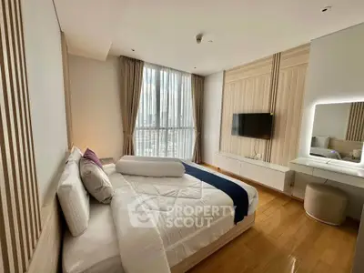 Luxurious bedroom with modern decor and large window offering city views