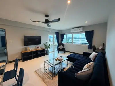 Spacious modern living room with stylish furniture and large windows offering natural light and scenic views.