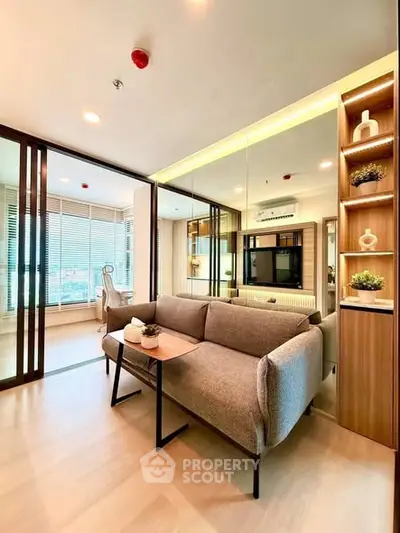 Modern living room with stylish decor and natural light, featuring a cozy sofa and elegant shelving.