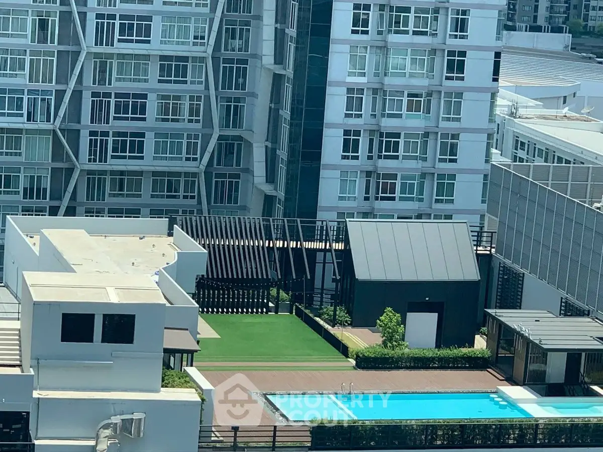 Modern urban apartment complex with rooftop pool and garden area.