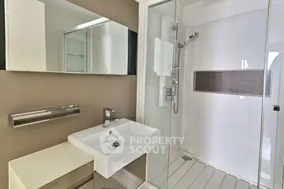 Modern bathroom with sleek shower and stylish sink in contemporary apartment.