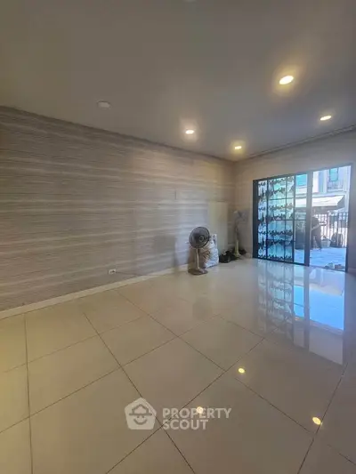 Spacious unfurnished living room with tiled flooring and sliding glass doors
