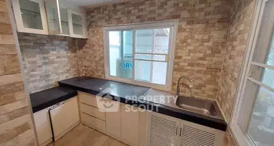 Modern kitchen with sleek countertops and stylish brick backsplash