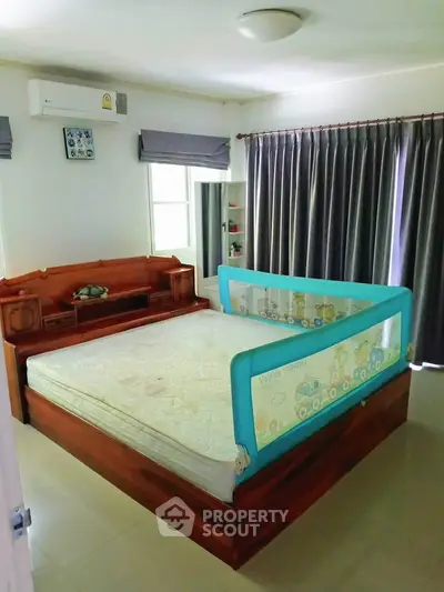 Spacious bedroom with large bed and ample natural light, perfect for restful nights.