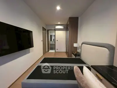 Modern bedroom with sleek design and wall-mounted TV in a contemporary apartment.