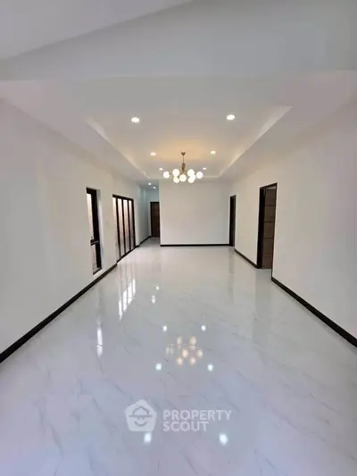 Spacious modern living room with elegant lighting and glossy white flooring