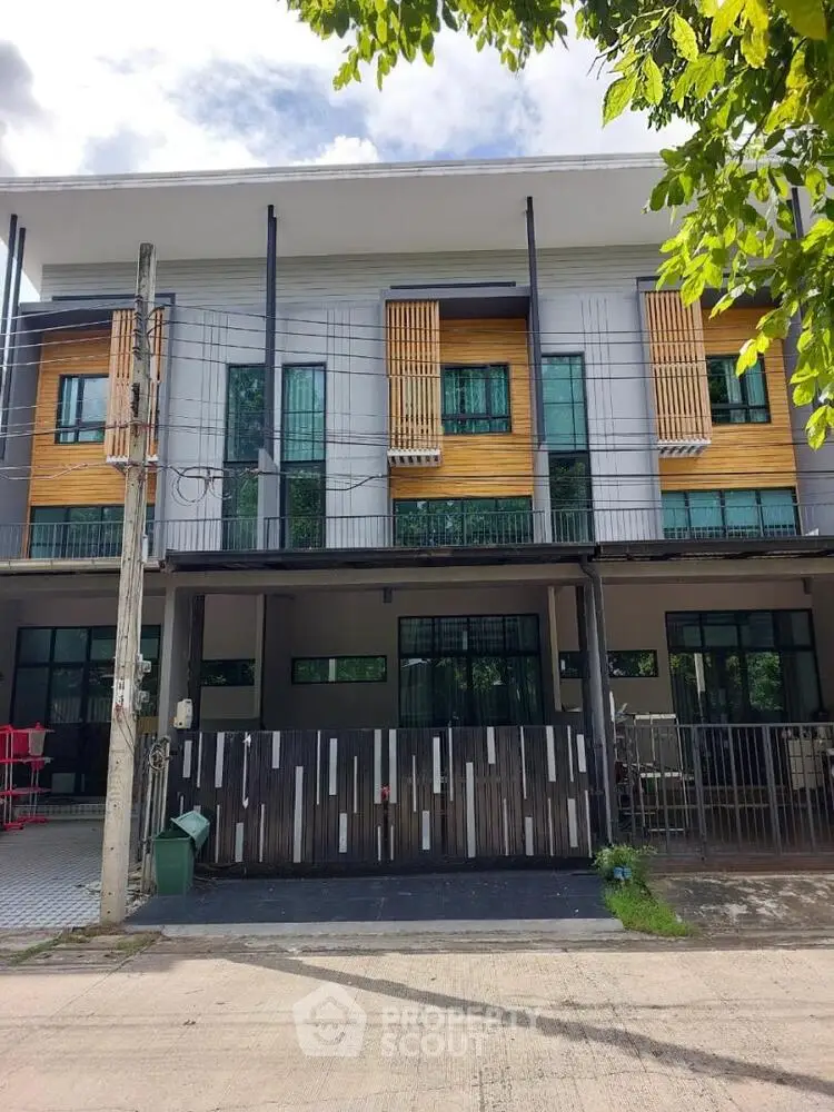 Modern townhouse exterior with stylish facade and large windows in a serene neighborhood.