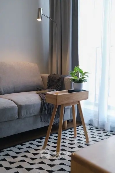 Modern living room with stylish sofa, wooden side table, and cozy decor