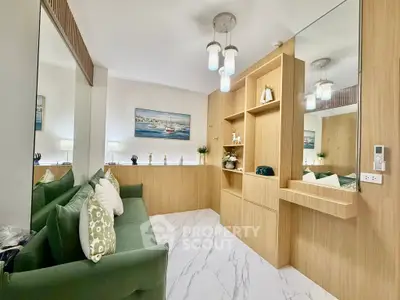 Stylish living room with modern decor and elegant lighting, featuring a cozy green sofa and sleek wooden cabinetry.