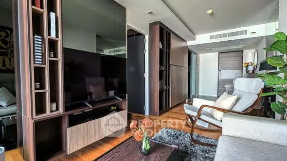 Modern living room with sleek furniture and large TV, featuring wooden accents and cozy decor.