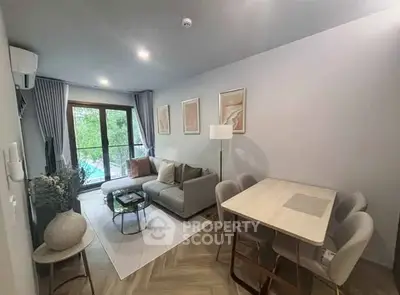 Modern living room with elegant decor and dining area, featuring large windows and stylish furniture.