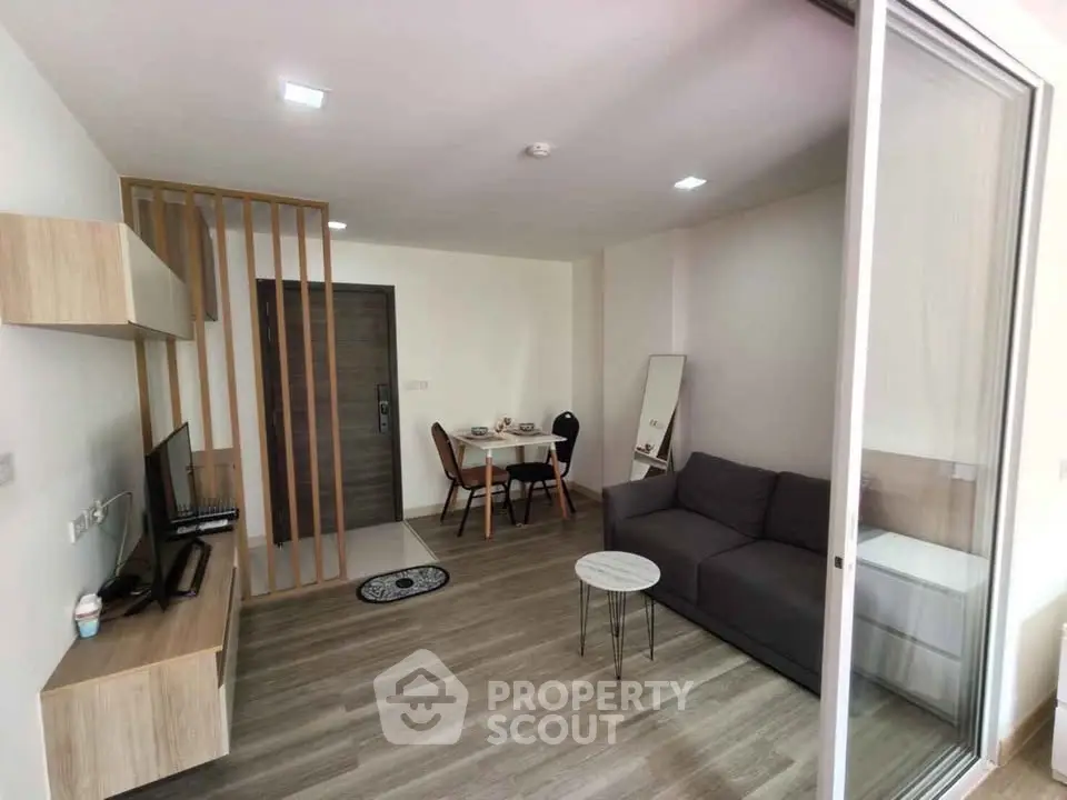 Modern living room with sleek furniture and open layout, featuring a cozy dining area and stylish decor.