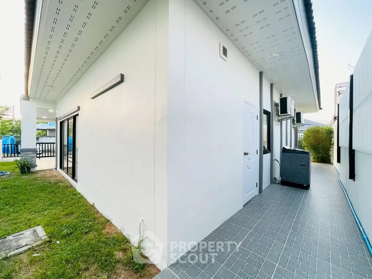 Modern exterior view of a single-story home with clean lines and a spacious side yard.