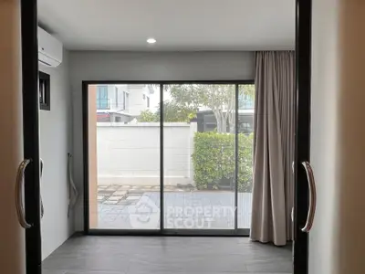 Modern room with sliding glass doors leading to a private patio.