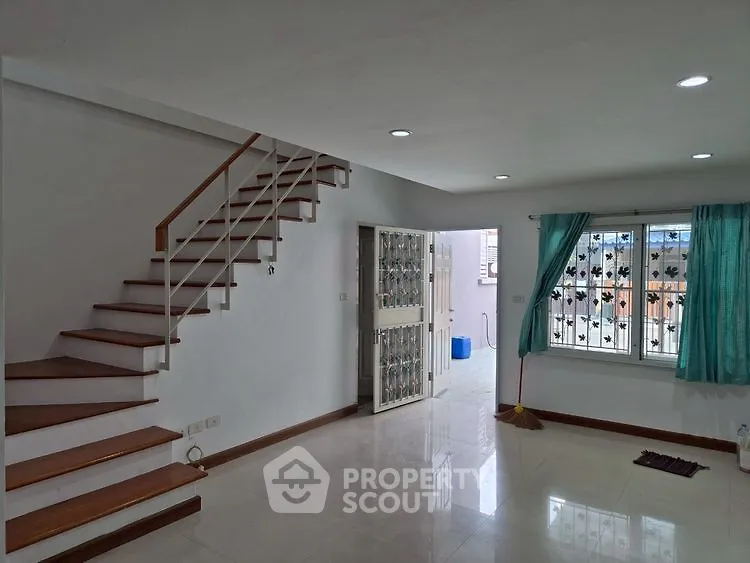 Spacious modern living room with staircase and natural light