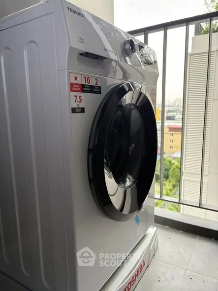 Modern washing machine on a balcony with city view, perfect for urban living convenience.