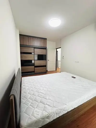 Spacious bedroom with modern wardrobe and comfortable bed in a stylish apartment.