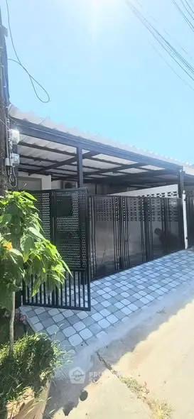 Modern gated entrance with sleek metal design and tiled pathway