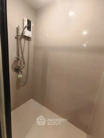 Modern bathroom shower area with sleek tiles and showerhead