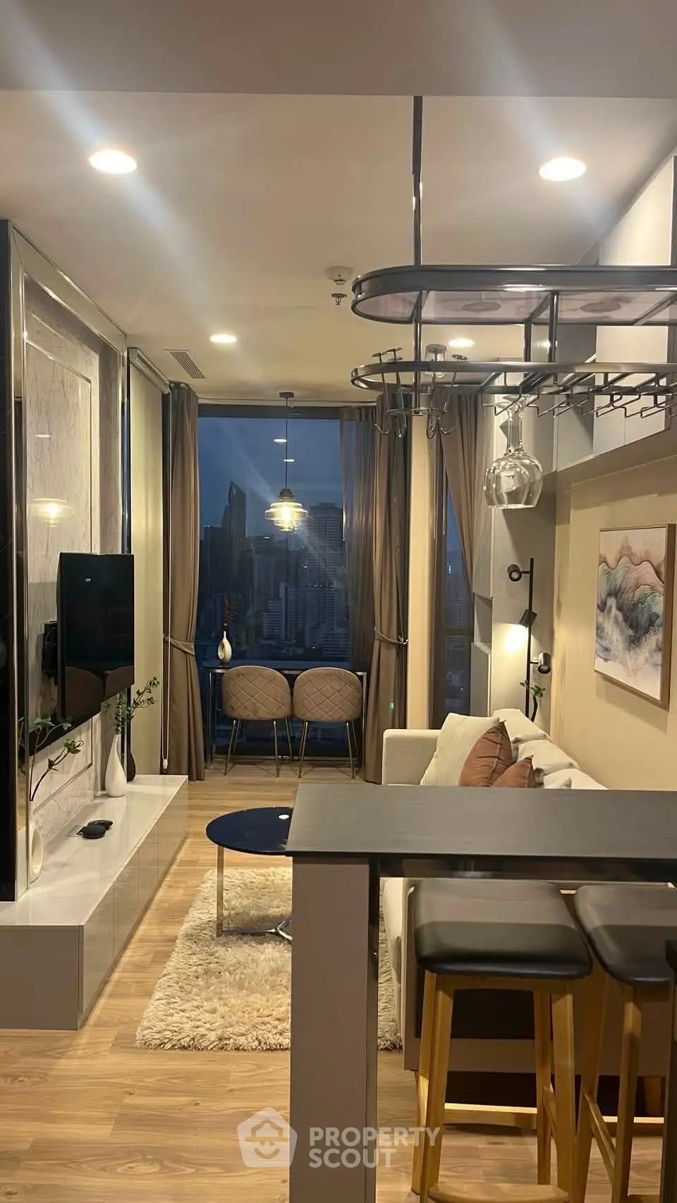 Modern living room with city view, stylish decor, and cozy seating area in a high-rise apartment.