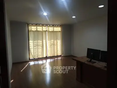 Spacious study room with wooden flooring and natural light