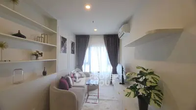 Modern living room with elegant decor, cozy seating, and natural light from large window.