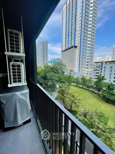 Spacious balcony with stunning cityscape view and lush greenery, perfect for relaxation and enjoying urban living.