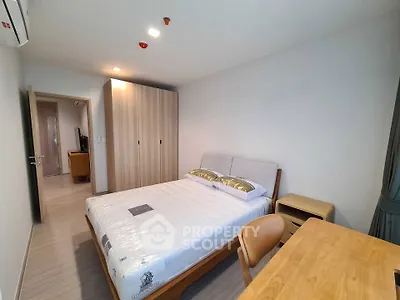 Modern bedroom with wooden furniture and ample natural light in a stylish apartment.