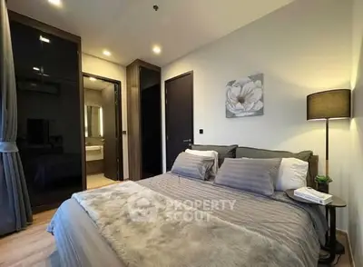 Luxurious bedroom with modern decor and ensuite bathroom in a stylish apartment.
