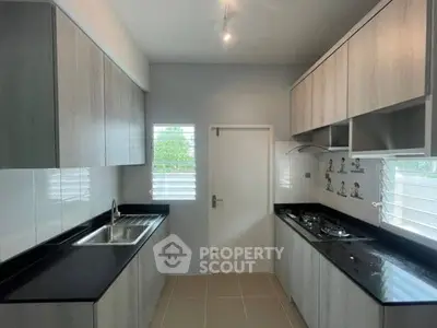 Modern kitchen with sleek cabinetry and gas stove in a bright, airy space.