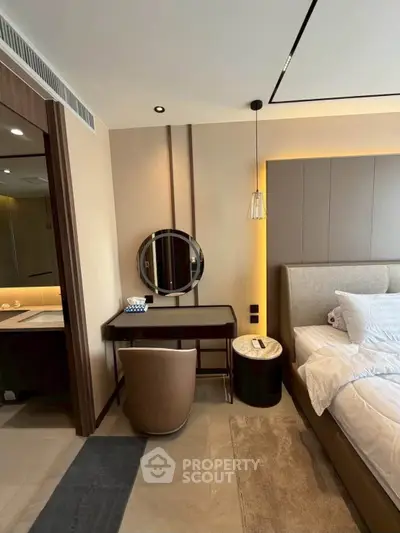 Luxurious bedroom with modern decor and elegant lighting, featuring a stylish vanity and plush bedding.