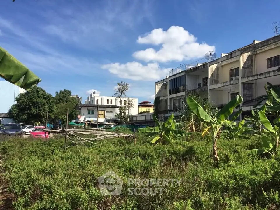 Charming urban garden view with residential buildings and lush greenery under a clear blue sky.