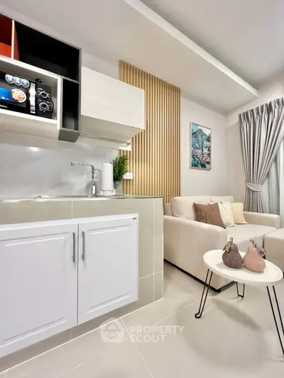 Modern open-layout kitchen and living room with stylish decor and neutral tones.