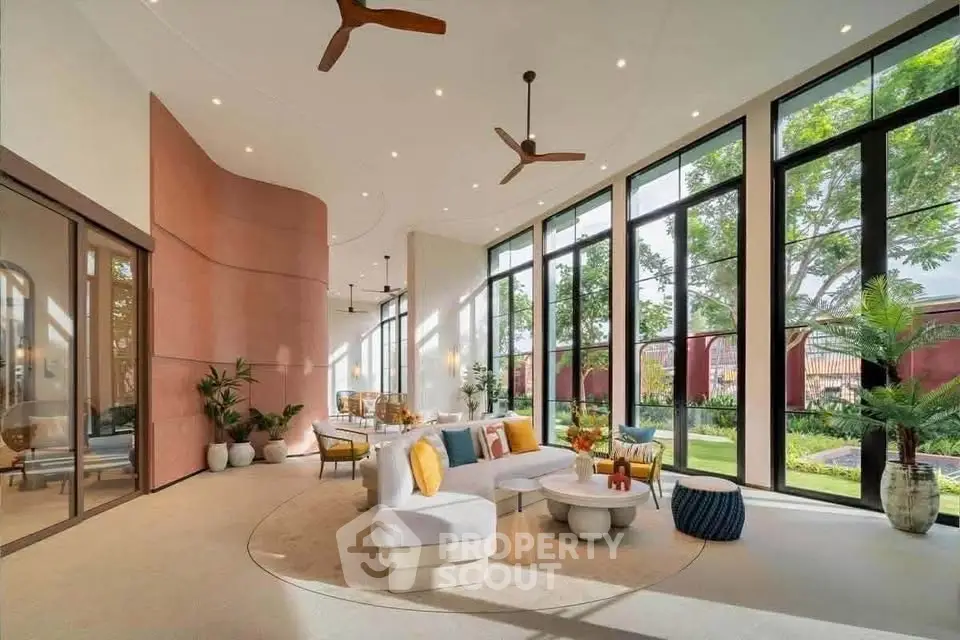Luxurious modern living room with floor-to-ceiling windows and elegant decor, offering a stunning garden view.