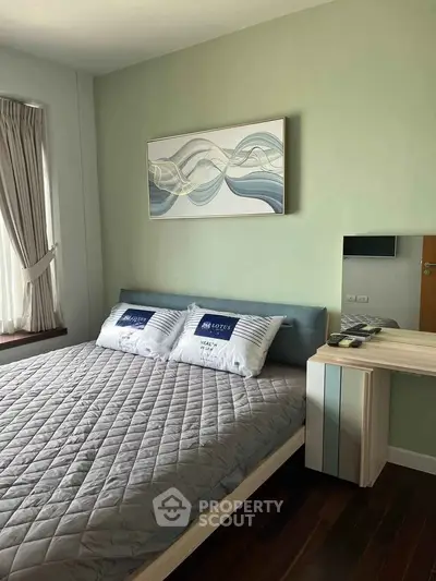 Cozy bedroom with modern decor and large window for natural light.