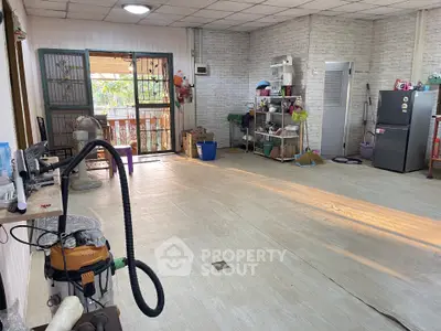 Spacious interior with open layout and natural light, featuring storage shelves and appliances.
