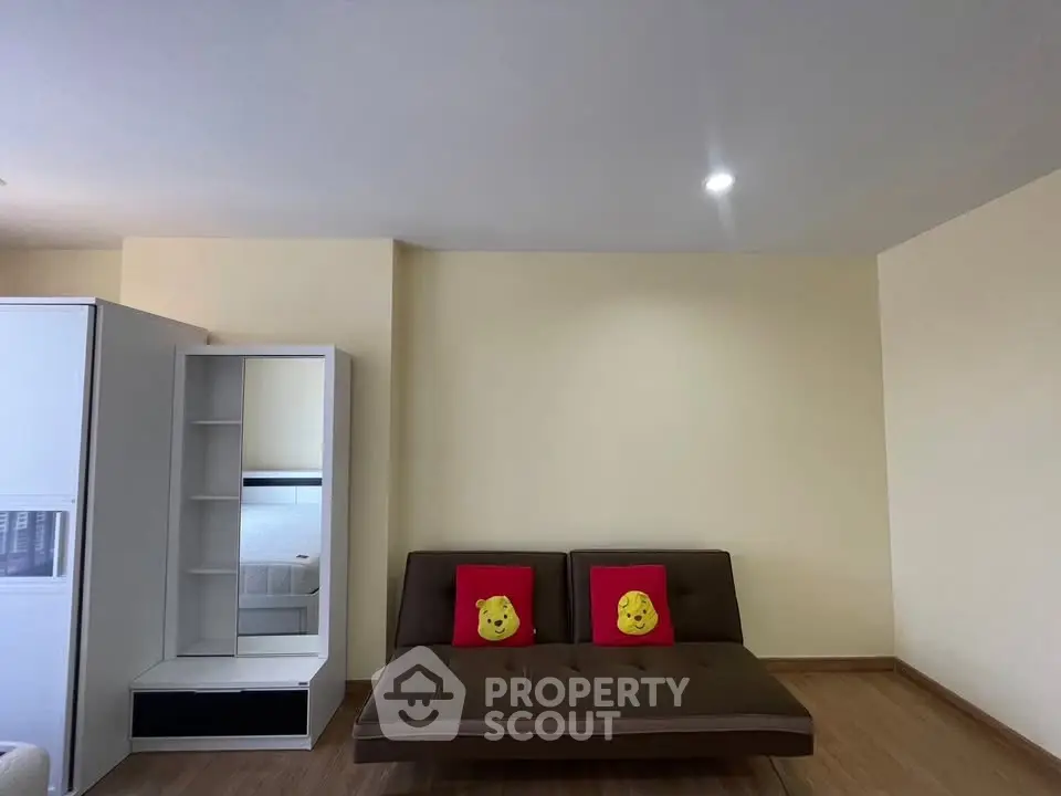 Modern living room with brown sofa and decorative pillows in a minimalist apartment.